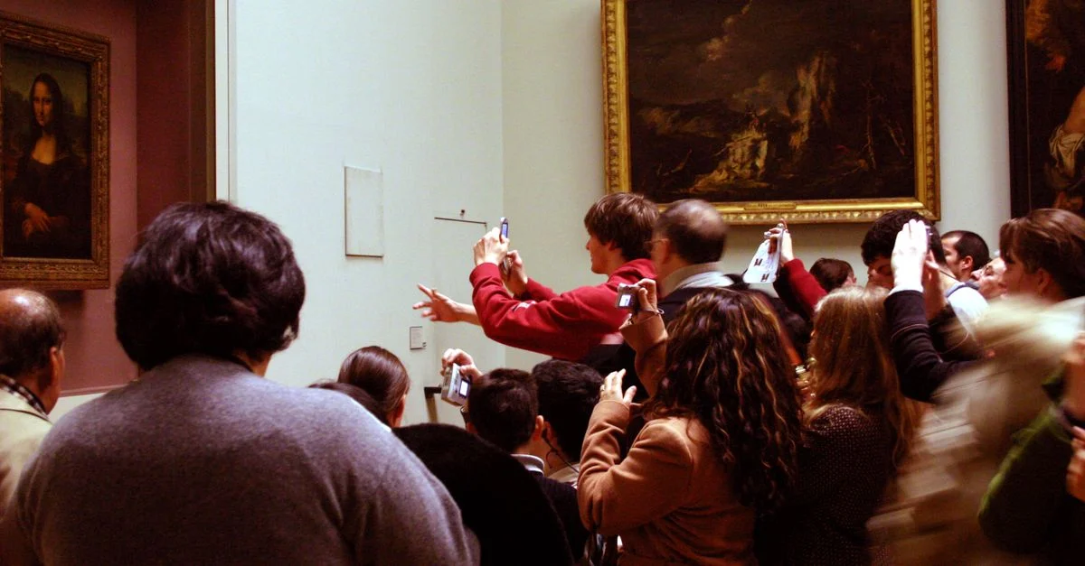 Des visiteurs prennent des photos de la Mona Lisa dans le Musée du Louvre bondé à Paris.