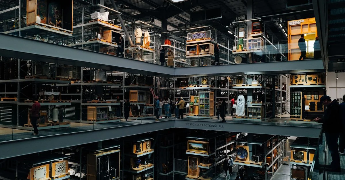 Une vue fascinante de l'intérieur d'un musée d'art moderne à plusieurs étages, où des visiteurs observent les expositions.
